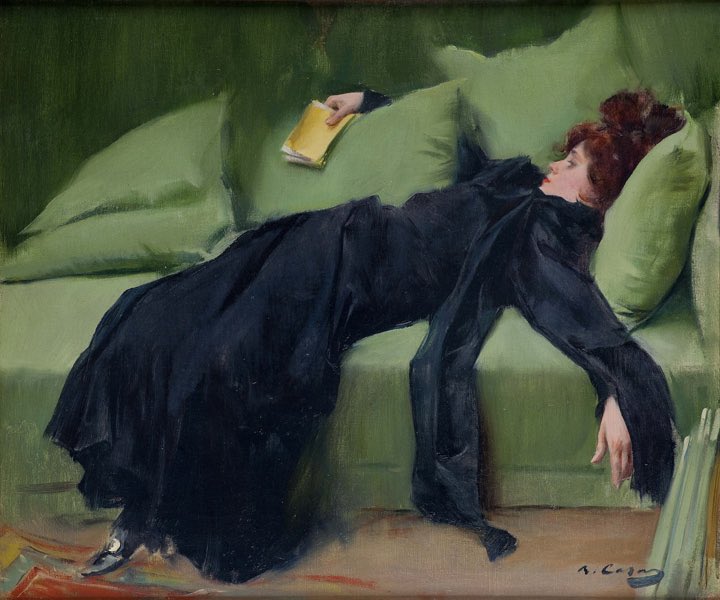 Une femme en robe noire allongée sur un canapé, un livre à la main